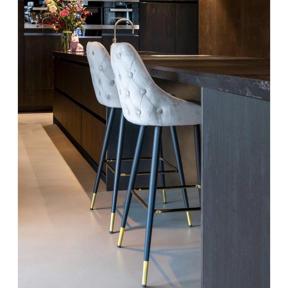 Two Airmani khaki velvet bar stools with tufted backs, black metal legs, and gold accents.