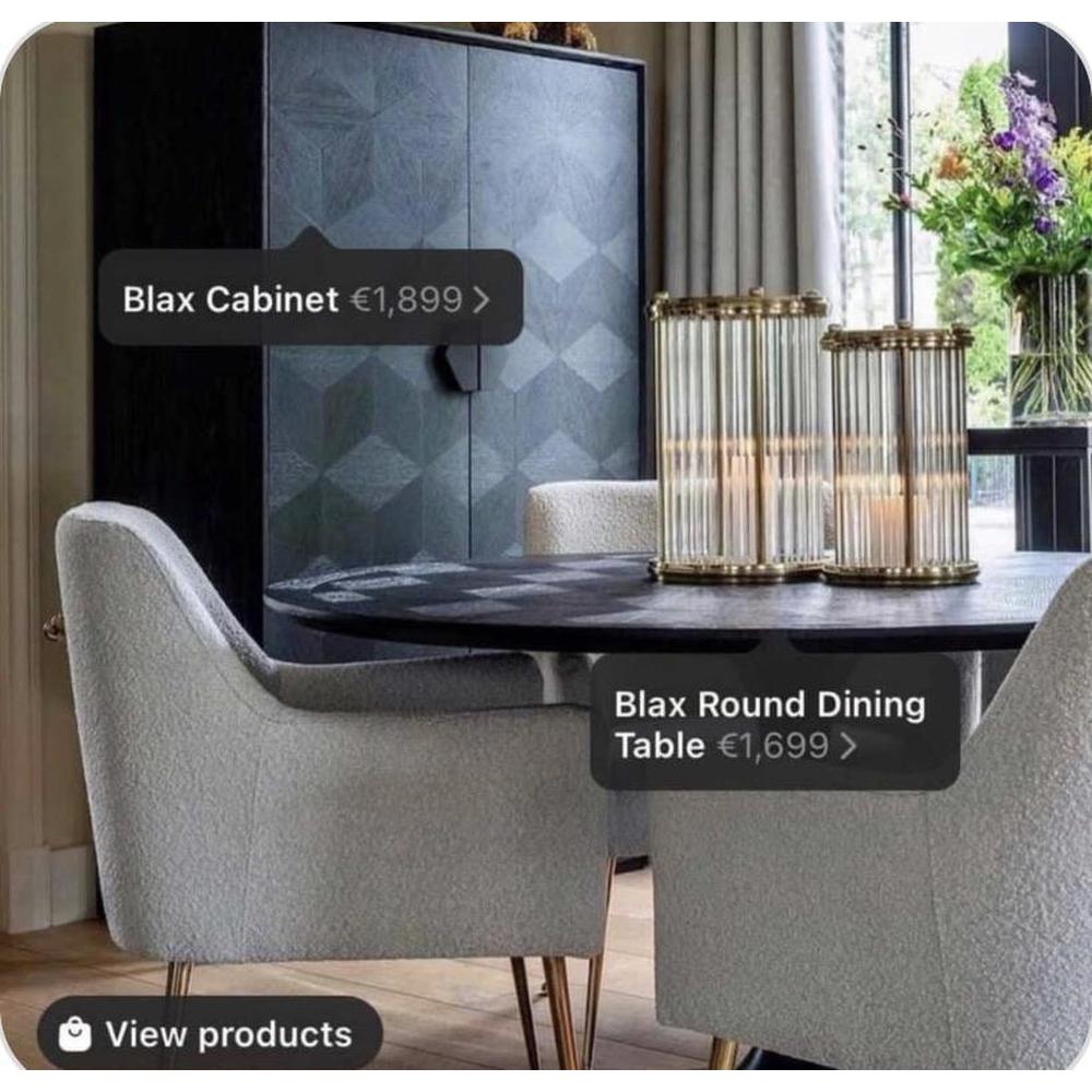 Blade Large Round 140cm Dining Table in black with textured surface, surrounded by light grey chairs.
