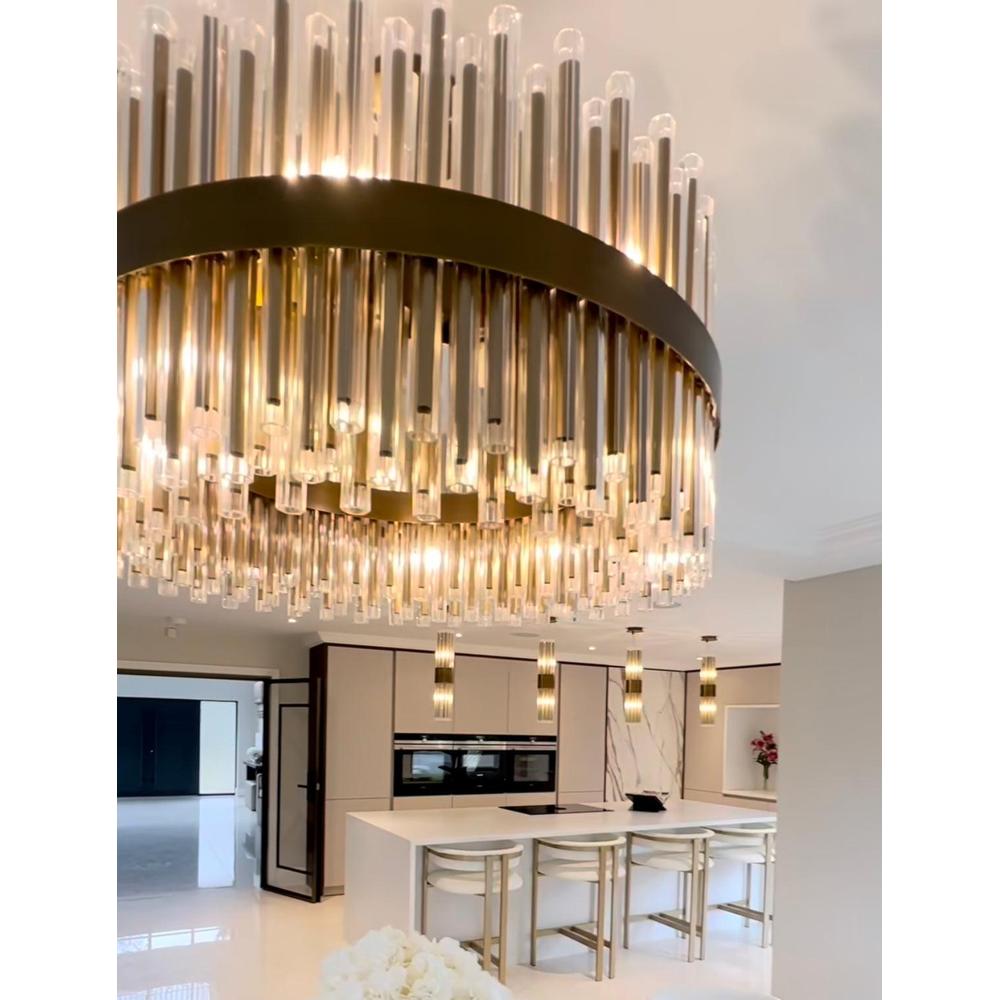 Colmar 80cm brushed brass chandelier with clear glass rods illuminating a modern kitchen island.
