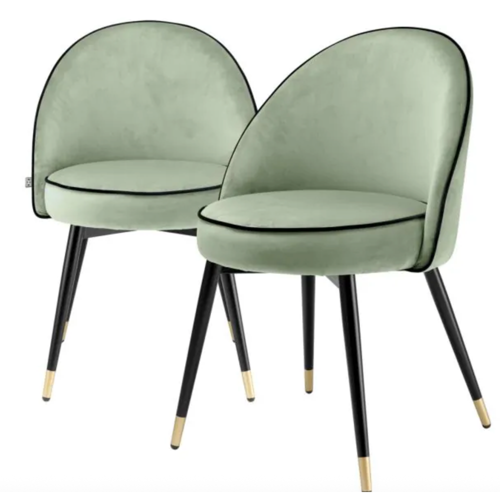 Set of 2 Eichholtz Cooper dining chairs in light green velvet with black piping and black & brass legs.
