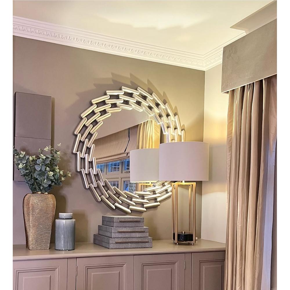 Lanthe large round silver leaf mirror with an oversized link frame, reflecting a room with a lamp and curtains.