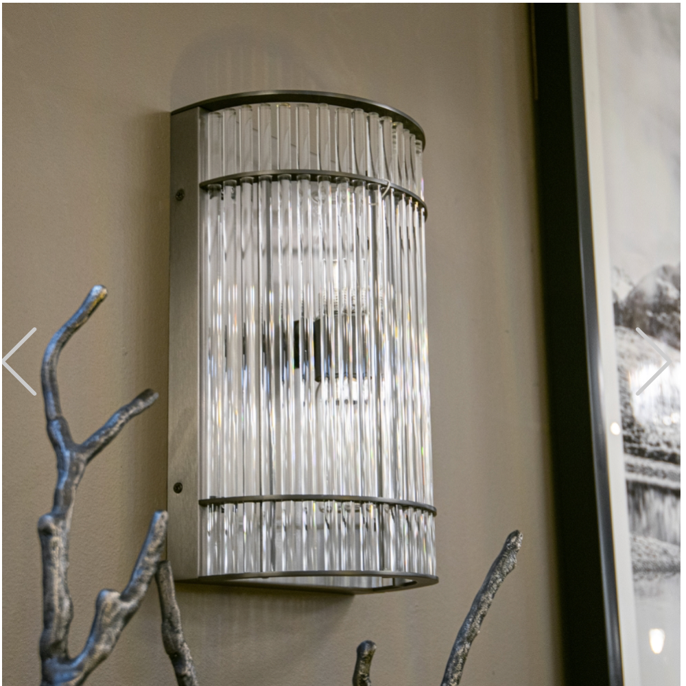 Macy Art Deco nickel wall light with clear fluted glass rods, mounted on a beige wall.