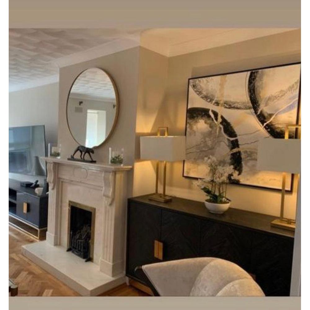 Black Chelsea Blake TV unit cabinet with gold accents, two lamps, and abstract art in a living room.