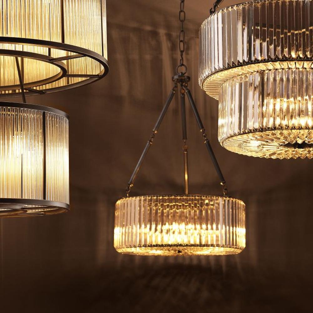 Eichholtz Infinity Crystal Chandelier with fluted glass shades and bronze finish, illuminating a warm glow.