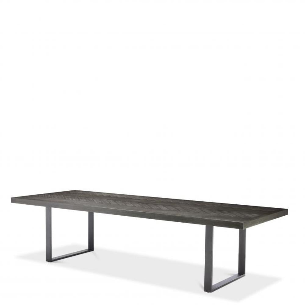 Melchior large designer dining table with charcoal oak veneer top and bronze finish U-shaped legs.