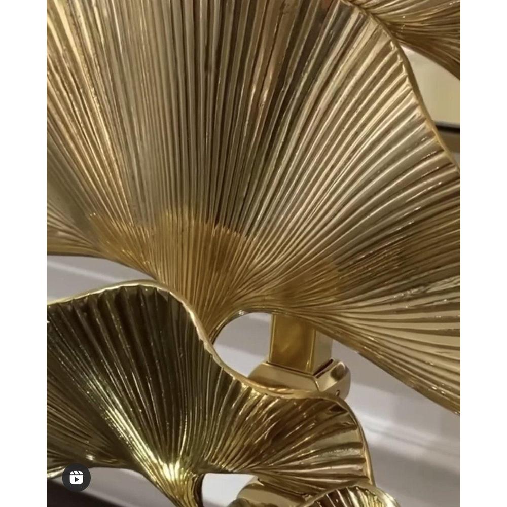 Close-up of polished brass palm leaves on the Olivier table lamp by Eichholtz.