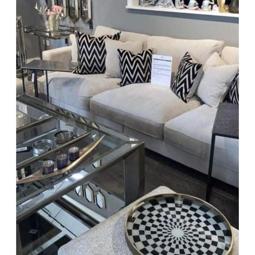 Eichholtz Tuscany XL designer sofa in light sand fabric with black feet and chevron cushions.